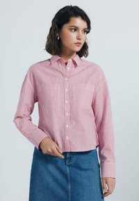 Gestreepte button-up shirt in rood en wit, met lange mouwen, een kraag, twee borstzakken en een cropped snit. Gepaard met een spijkerrok.
