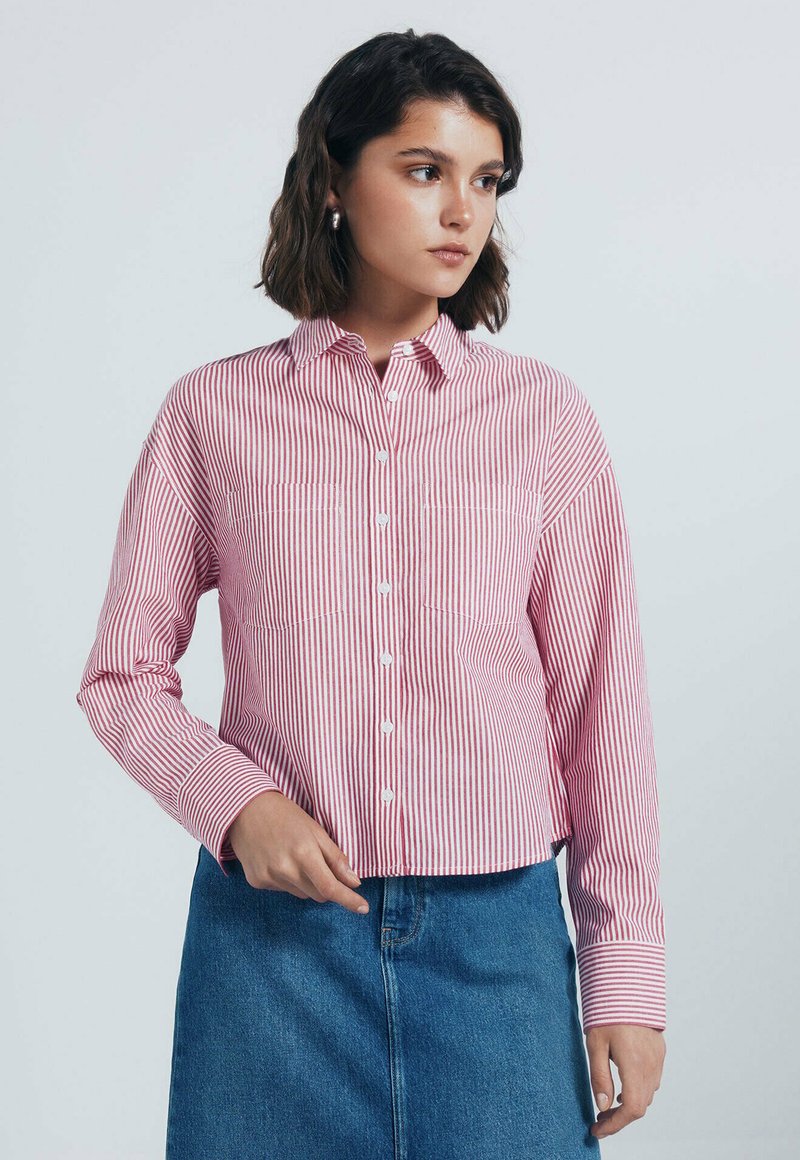Gestreepte button-up shirt in rood en wit, met lange mouwen, een kraag, twee borstzakken en een cropped snit. Gepaard met een spijkerrok.