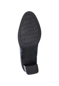 Sole view of black heeled shoe with textured grip pattern and square heel, showing brand name "Unisa" and size 37.