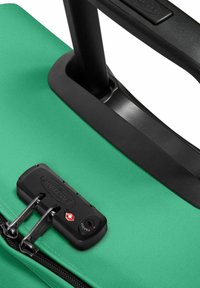 Zelená texturová zavazadla s černou rukojetí, vybavená zipem a kombinovaným zámkem s červeným akcentem. Odolná tkanina s zesílenými komponenty.