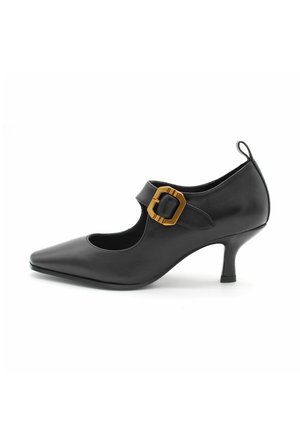 Zwarte leren high heel schoen met puntige neus en uitgesneden ontwerp. Beschikt over een tan kleurige gesp als accent en een smalle hak. Gladde textuur.