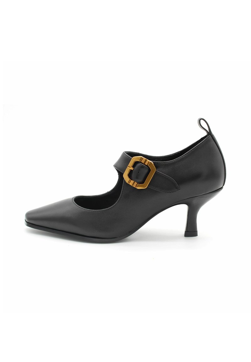 Scarpa nera in pelle con tacco alto, punta affilata e design a ritaglio. Presenta un accentuatore beige con fibbia e un tacco sottile. Texture liscia.