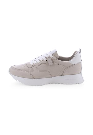 Baskets de sport beige clair avec lacets blancs, tige en cuir lisse, col rembourré et semelle en caoutchouc texturée avec des motifs en zigzag.