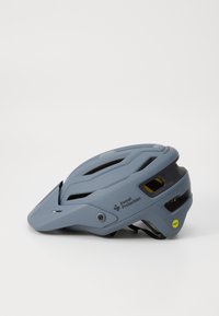 Un casco per mountain bike grigio con una forma aerodinamica, numerose aperture di ventilazione e un parafango. Presenta un'etichetta MIPS e il logo del marchio sul lato.