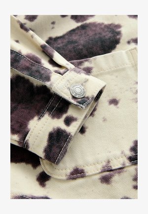 Cotton shirt with a cream base, featuring a large dark brown and purple splatter pattern, snap closure, and stitched seams.