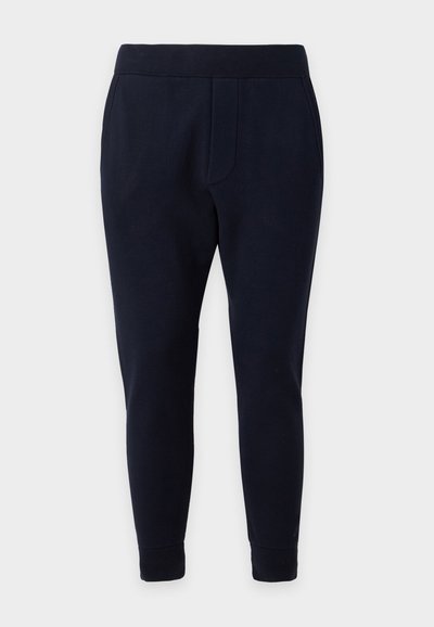 Pantalon jogger bleu marine slim avec taille élastique et poignets aux chevilles, conçu pour le confort et un usage décontracté.