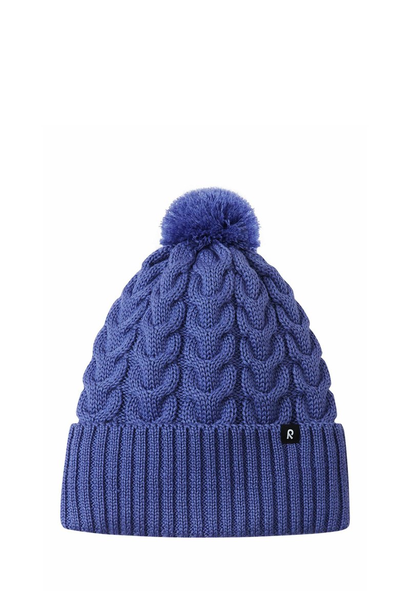 Blue knitted winter hat with cable pattern, ribbed cuff, pom-pom on top, and a small black tag on the cuff.