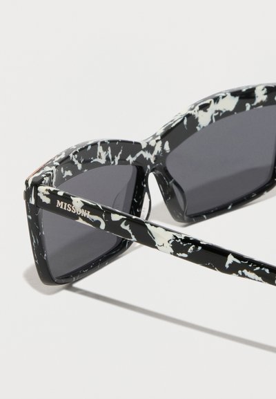 Fekete-fehér márványozott napszemüveg vastag kerettel, szürke lencsékkel és gravírozott logóval a szárakon. Elegáns, szögletes kialakítás.