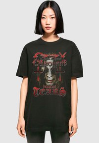 Schwarzes Baumwoll-T-Shirt mit einem zentralen Grafikdesign eines Gesichts mit Kreuzen, roten Akzenten und dem Text "Ozzy Osbourne No More Tears."