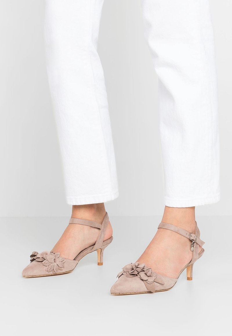 Escarpins slingback en daim beige avec un bout pointu, ornés d'accents floraux, d'une fine bride à la cheville et d'un petit talon.