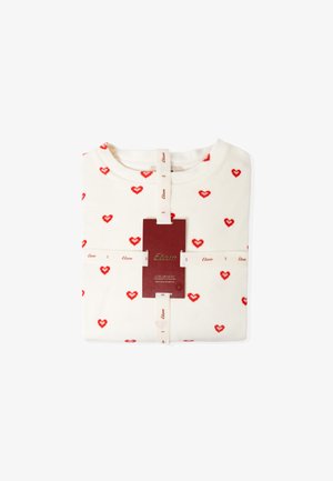 Sweatshirt blanc avec des motifs de cœurs rouges, plié soigneusement. Présente une étiquette avec "Etam" et un tag de taille. Tissu doux et col rond.