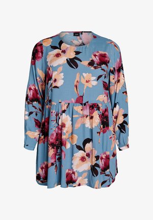 Blusa floral de manga larga, con un escote redondeado y un corte holgado. Presenta un fondo azul con grandes flores en tonos rosa, amarillo y granate.