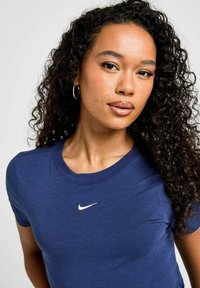 Camiseta de algodón azul marino de manga corta, cuello redondo, con un pequeño logo blanco de Nike en el pecho, textura suave.