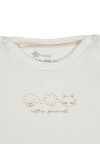White baby bodysuit with light brown illustrations of a dog, sheep, and cat, labeled "little friends," featuring snap buttons at the collar.