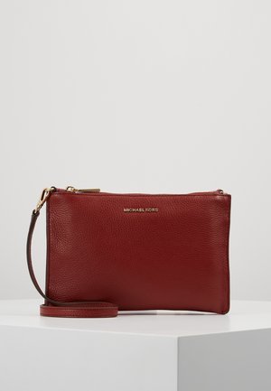 Rødt læder armbånds clutch taske med guldlås og rem, præget med Michael Kors logo foran.