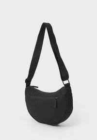 Schwarze Schultertasche aus weichem Stoff. Abgerundete Form mit einer Reißverschlusstasche auf der Vorderseite und einem verstellbaren Tragegurt. Erscheint leicht und strapazierfähig.