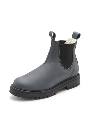 Black leather Chelsea boot with chunky sole, elastic side panels, pull tabs, and white fleece lining visible at the ankle collar.
