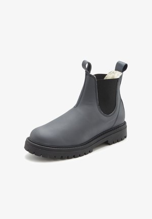 Black leather Chelsea boot with chunky sole, elastic side panels, pull tabs, and white fleece lining visible at the ankle collar.