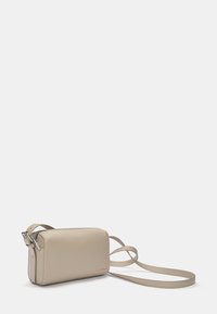 Sac bandoulière en cuir beige avec fermeture éclair, de forme rectangulaire, sangle fine et ajustable, et design minimaliste. Texture lisse, sans motifs.