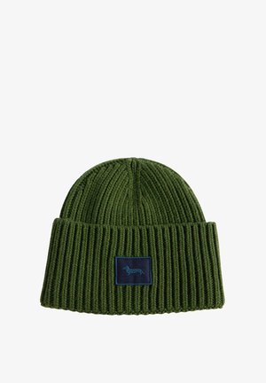 Beanie verde lavorato a maglia con trama a costine, dotato di un'etichetta rettangolare blu navale con il profilo di un cane. Lo stile è aderente e semplice.
