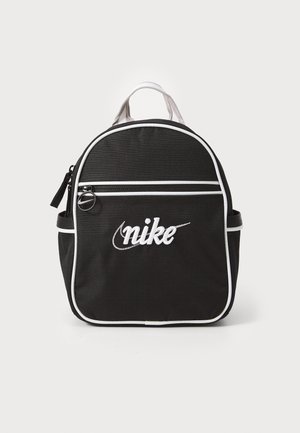 Sac à dos noir Nike avec passepoil blanc, poche avant zippée, poches latérales et poignée de transport sur le dessus.