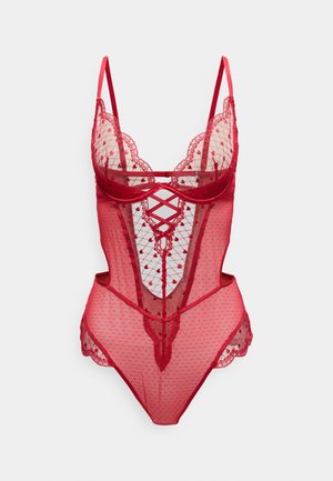 Body en dentelle rouge avec filet transparent, motif à pois, bords festonnés et détail de lanières croisées. Bretelles spaghetti réglables.