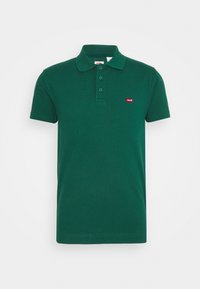 Polo à manches courtes vert foncé avec trois boutons et un petit logo rouge Levi's sur le côté gauche de la poitrine.