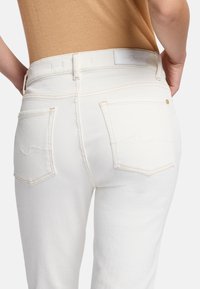 Witte denim jeans met een minimalistisch ontwerp, met subtiele stiksels, twee achterzakken en een taillebandlabel. Soepele textuur.