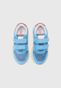 Chaussures en suède bleu avec des bandes Velcro, présentant un accent bleu plus foncé, un doublage blanc et une semelle en caoutchouc. Détail du talon rouge remarqué.
