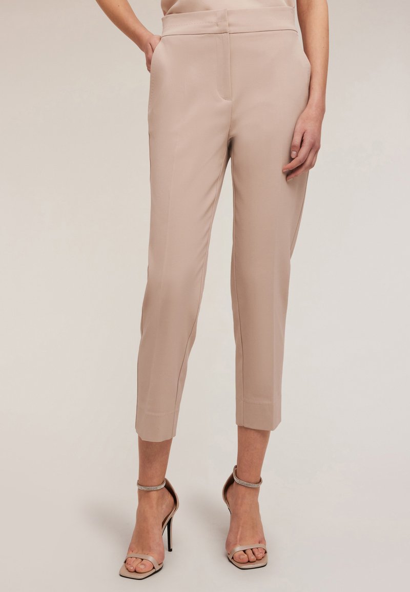 Pantaloni bej, croiți, cu o siluetă slim, tăiati la lungimea cropped și cu o textură netedă. Dispun de buzunare laterale și un talie plată. Asortați cu tocuri nude.