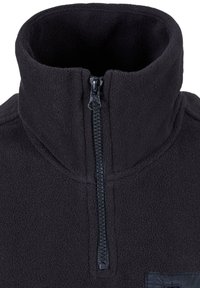 Pullover felpato nero con colletto alto, dotato di una zip quarti di lunghezza e una superficie liscia. Include un piccolo patch sul lato sinistro.