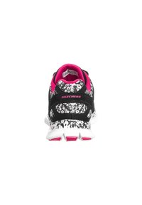 Black and white sneaker with a spotted pattern, pink accents, and a cushioned heel. Features a white sole with flexible grooves.