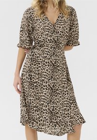 Klänning i leopardtryck med v-ringning, korta puffärmar, åtsittande midja och asymmetrisk fåll. Tillverkad av lätt, flödande tyg.