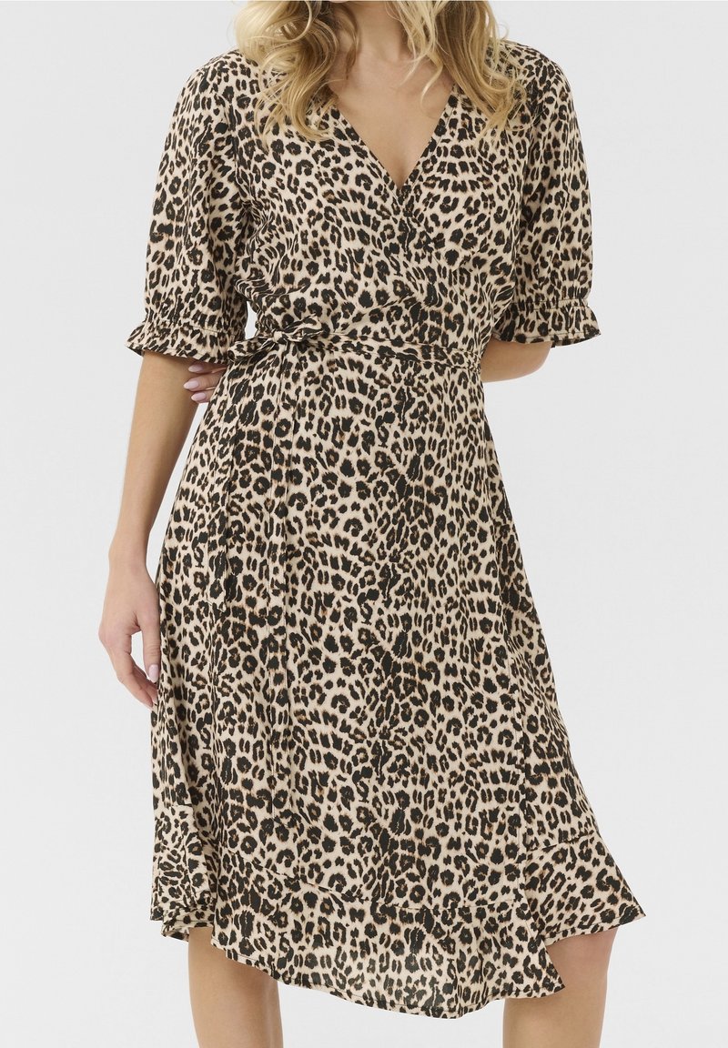 Klänning i leopardtryck med v-ringning, korta puffärmar, åtsittande midja och asymmetrisk fåll. Tillverkad av lätt, flödande tyg.