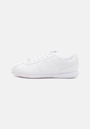 Lavprofil hvid lædersneaker med snørelukning foran og tekstureret sål, vist fra siden mod en ensfarvet baggrund.