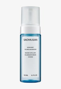 Klar blå flaske med en hvit pumpe, merket "Sachajuan Ocean Mist Volume Hair Mousse," 150 ml. Enkel, moderne design med minimal tekst.