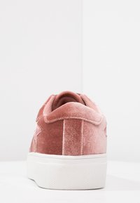 Satinrosa sneakers med vit gummisula, med en något upphöjd häl och en stjärnformad detalj på sidan. Strukturerad tygytfinish.