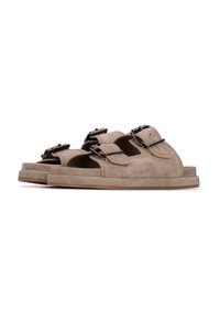 Sandali in suede marrone con due cinturini regolabili. Presentano un design con la punta aperta, suola piatta e superficie texturizzata. Stile casual.