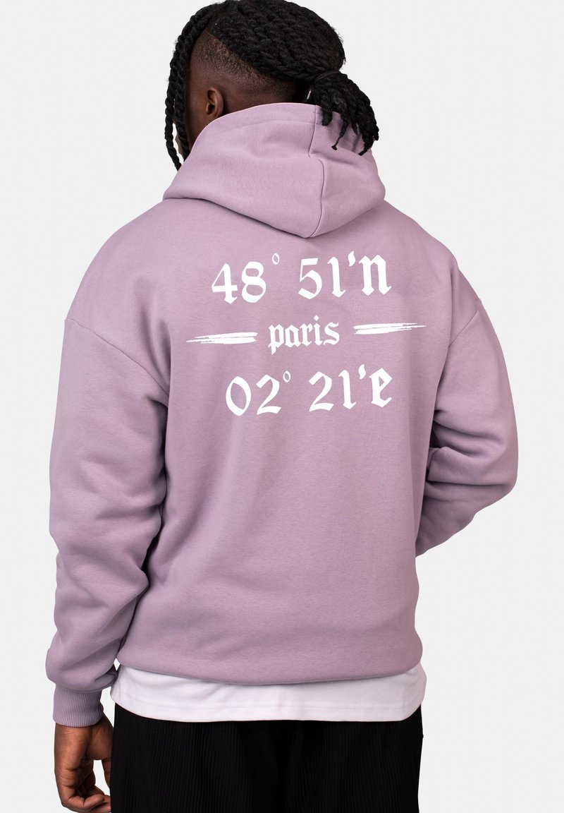 Hoodie lavande avec du texte blanc au dos : "48° 51'N paris 02° 21'E." Fabriqué en tissu doux, avec une coupe décontractée et une capuche.