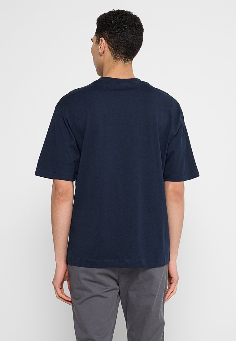 Marineblaue Baumwoll-T-Shirt mit kurzen Ärmeln, Rundhalsausschnitt und lockerer Passform. Nahtloser Rücken und weiche Textur ohne Muster.