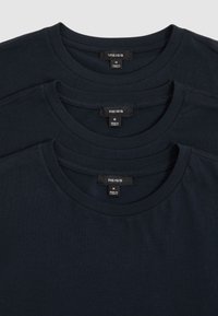 Drei schwarze mittelgroße Crewneck-T-Shirts der Marke Reiss, gestapelt mit sichtbaren Etiketten mit der Aufschrift „Made in Turkey.“