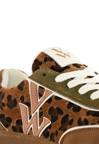Baskets imprimées léopard avec un dessus en fausse fourrure marron, des accents en daim vert olive, des lacets blancs et un logo bien visible sur la languette.