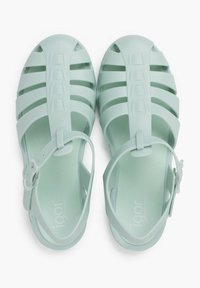 Heledad mintsrohe plastikust sandaalid suletud varvade, avatud külgede ja reguleeritava pahkluu rihmaga. Omavad horisontaalset ja vertikaalset lõikeava.