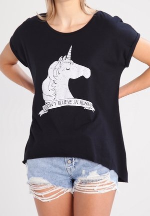Czarna koszulka z białą ilustracją jednorożca i napisem „Nie wierzę w ludzi”, zestawiona z podartymi jasnymi krótkimi szortami dżinsowymi.