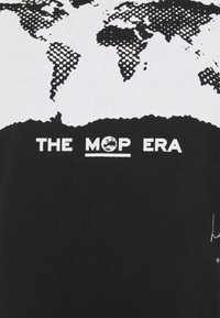 Černé bavlněné tričko s texturovaným grafikou světa v bílé barvě, s nápisem "THE MOP ERA" níže a kruhovým logem uprostřed.