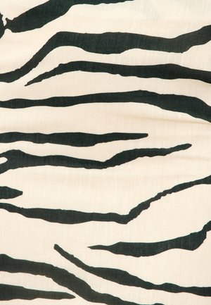 Tissu blanc avec des rayures noires irrégulières ressemblant à des zèbres, formant un motif animal abstrait et audacieux.