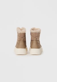 Ruske puffer ankle botas s faux krznom ovratnikom, zatvaranjem na patentni zatvarač i teksturiranim smešanim materijalom; bela gumena sredina s podignutom petom.