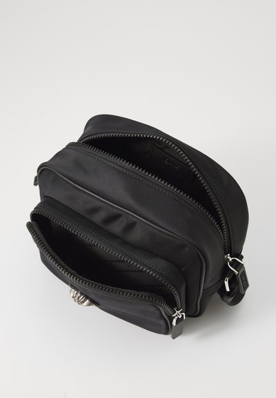 Geanta crossbody din nailon negru, cu multiple compartimente cu fermoar, textură netedă, formă rotundă și accente din metal argintiu.