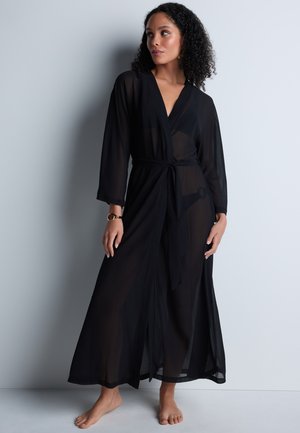 Robe noire longue en style kimono, transparente, avec un design enveloppant, une taille à nouer et des manches longues. Texture lisse, longueur jusqu'aux chevilles, style minimaliste.