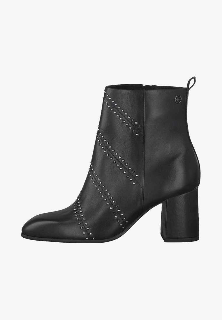 Bottine en cuir noir avec un bout pointu, un talon carré et des clous métalliques décoratifs disposés en lignes diagonales sur le côté.
